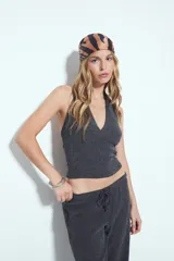 Top de cuello halter color gris oscuro, con escote en V pronunciado en el frente y espalda descubierta. Presenta textura acanalada.