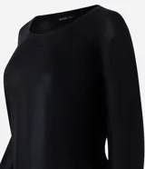 Blusa negra de punto liviano con escote redondo, manga larga y sisa raglán. Tiene una malla con lámina metálica.