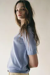 Top celeste de punto fino con cuello redondo y mangas cortas.
