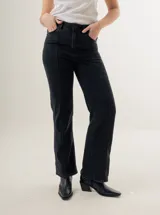 Pantalón de jean azul oscuro, de corte recto y tiro alto, con bolsillos delanteros y traseros. Presenta costuras verticales en el frente.