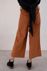 Pantalón capri color beige de pana con tiro alto, corte ancho y bolsillos laterales.