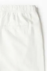 Short blanco de lino y algodón, con corte relajado, cintura elástica con cordón ajustable, bolsillos laterales y bolsillo trasero insertado.
