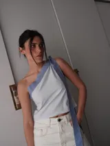 Top celeste y blanco a rayas horizontales, con escote asimétrico y bretel ancho color rosa.