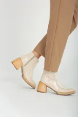 Botas de cuero blancas con tacón de madera y cierre lateral.