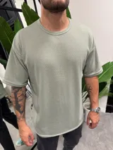 Remera verde claro de punto con cuello redondo y corte holgado.