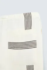 Pantalón de lino color crudo con rayas verticales negras, corte relaxed fit, cintura elástica ajustable con cordón, bolsillos laterales y traseros.