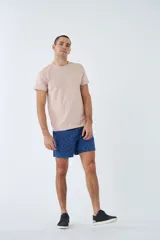 Short de baño celeste con estampado de líneas curvas en azul. Cuenta con cintura elástica con cordón ajustable, dos bolsillos laterales, un bolsillo trasero, suspensor interno y logo bordado.