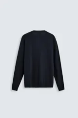 Jersey color topo de corte amplio, tejido en hilatura con mezcla de viscosa. Tiene cuello redondo, manga larga y terminaciones en rib.
