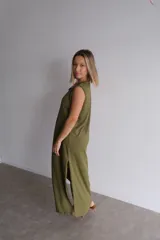 Vestido largo azul marino de tejido acanalado, con escote redondo y mangas cortas tipo hombrera. Presenta una abertura lateral en la falda.