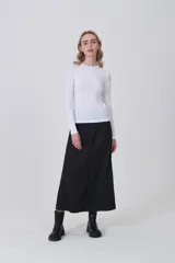 Remera de manga larga ajustada al cuerpo, color negro, con cuello redondo a la base y tejido acanalado.