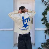 Camiseta manga larga color beige de corte cuadrado, con estampado frontal y trasero en azul con la frase "I'm Lookmom" y una estrella.