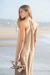 Vestido largo color beige con escote en V y tirantes finos, confeccionado en algodón.