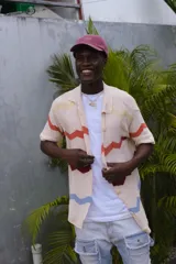 Camisa de tejido de punto oversize con botones en el frente y diseño a rayas horizontales en tonos beige, rojo, marrón y celeste.