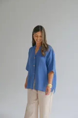 Camisa azul jean de lino, con cuello mao, manga corta y cierre frontal con botones.