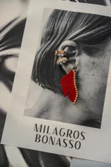 Aro con forma de media flor color rojo con detalle de strass dorados.