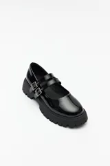 Guillerminas blancas de cuero sintético con suela track negra y doble tira ajustable con hebillas metálicas.