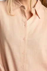 Camisa color salmón de corte oversize, confeccionada en lino y viscosa, con cuello clásico, cierre frontal con botones y mangas largas con puños anchos.