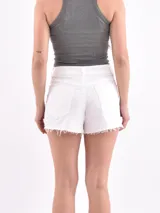 Short de jean blanco con terminación desflecada.