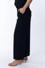 Pantalón negro de lino, de corte palazzo y tiro alto.