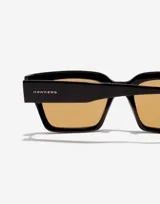 Lentes de sol unisex Hawkers modelo Mate Black Mustard Eco, con montura cuadrada negra y cristales color mostaza.