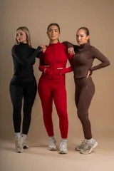 Conjunto deportivo rojo compuesto por calza tiro alto y campera con cierre frontal y bolsillos laterales.