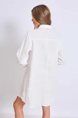 Vestido camisero corto color crudo, de lino, con cuello camisero, mangas largas y cierre frontal con botones. Presenta apliques de encaje en cuello y hombros.