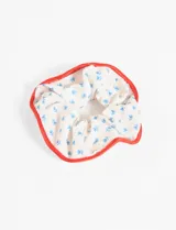 Scrunchie con estampado floral y bordes rojos, fabricado en poliéster y elastano.
