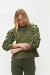 Remera negra de punto con mangas largas abullonadas con volantes.