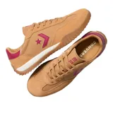 Championes Converse Run Star Trainer Ox color mostaza, con detalles en fucsia y blanco. Presentan el logo de la estrella y el chevrón en fucsia en el lateral, y suela de goma con diseño ondulado.