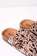 Zuecos con estampado animal print color camel y negro, con hebilla metálica ajustable y suela de corcho.