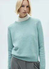 Sweater color crema de tejido de punto grueso con cuello redondo y mangas largas.