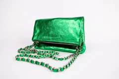 Cartera tipo sobre color verde esmeralda metalizado, con cierre de cremallera y correa de cadena metálica plateada.