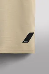 Camiseta deportiva de entrenamiento, corte regular fit, color gris claro, con cuello redondo y manga corta. Confeccionada en tejido técnico ligero y elástico con estructura Quick Dry nivel 2. Presenta costuras planas y un pequeño logo estampado en la parte inferior derecha.