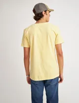 Remera de algodón teñida con un diseño de arte central que presenta la frase 'The sun will rise again'.
