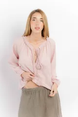 Blusa celeste de algodón con escote en V con lazos y mangas largas abullonadas con puños elásticos.