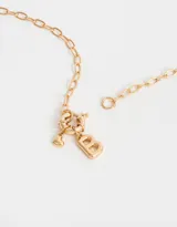 Collar corto dorado con cadena de eslabones, cierre de mosquetón, dije de corazón y dije de letra B.