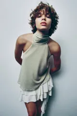 Top de cuello halter color beige, con lazada tipo foulard, forro interior y cierre lateral con cremallera oculta.