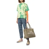 Bolso tote grande de lona color beige con asas de mano y cierre superior con cremallera. Estampado frontal con la leyenda "THE TOTE BAG MARC JACOBS" en letras blancas.