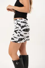 Minifalda blanca con estampado de peces negros, de silueta recta.