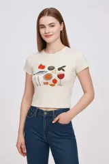Remera blanca de algodón con cuello redondo y mangas cortas. Estampado con dibujos de comida.