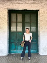 Cartera tipo tote bag de cuero color verde oliva, con doble asa corta de cuero marrón y correa larga extraíble y regulable de cuero marrón. Tiene un bolsillo frontal con cierre y un bolsillo interno.