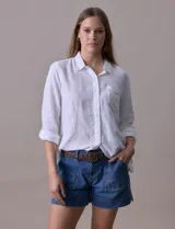 Camisa blanca de lino, marca Dash, con cuello con solapa, abertura central con botones, bolsillo aplicado en el pecho y mangas largas regulables con presilla y botón.