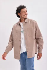 Sobrecamisa color beige con cuello camisero, cierre frontal con botones a presión, dos bolsillos de parche en el pecho y mangas largas con puños abotonados.