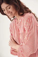 Camisa de manga larga con rayas verticales rojas y blancas, cuello clásico y bolsillo en el pecho.
