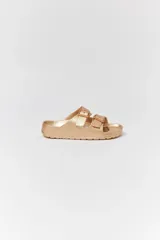 Sandalias de goma color dorado con doble tira y hebillas ajustables.