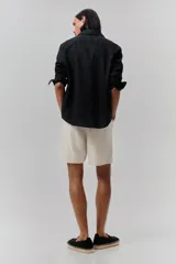 Short color crema en tejido liviano de algodón y viscosa. Modelo con cierre decorativo, elástico revestido con cordón para ajustar en la cintura, bolsillos al bies y bolsillo insertado atrás. Corte relajado para una silueta casual.