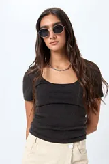 Remera color beige de punto acanalado, con escote redondo amplio y mangas cortas.