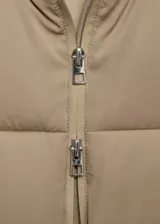 Campera puffer color beige con capucha, cierre frontal con cremallera y bolsillos laterales.