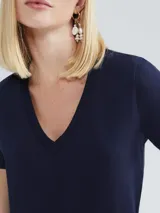Remera gris de corte clásico, con cuello en V y mangas cortas.
