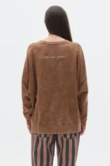 Buzo gris de algodón lavado, corte oversized, manga larga, hombros caídos y cuello redondo. Bordado pequeño en el frente y bordado grande en la espalda, ambos a tono.